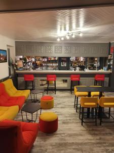 a restaurant with a bar with colorful chairs and tables at Hotel L'envie des mets in Lus-la-Croix-Haute