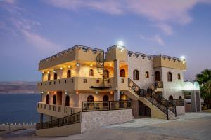 a building with a staircase in front of the water at The Dream Compound- by Biankini in Kalia