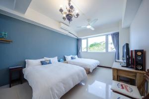 Camera blu con 2 letti e una TV di Bailuwar Anping B&B ad Anping