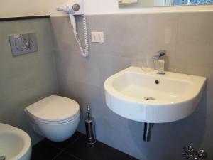 a bathroom with a sink and a toilet and a phone at Hotel La Spiaggia in Monterosso al Mare