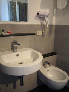 a bathroom with a sink and a phone on the wall at Hotel La Spiaggia in Monterosso al Mare