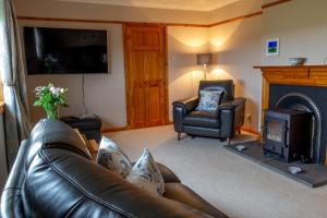uma sala de estar com um sofá de couro e uma lareira em Ar Dachaigh, North Uist em Paible