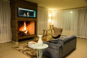 sala de estar con sofá y chimenea en Hotel Vila Verde, en Nova Friburgo