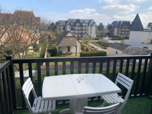 a white table and chairs on a balcony at Appartement Cabourg bord de mer in Cabourg