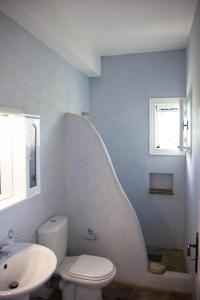 a white bathroom with a sink and a toilet at Agkeria great feeling house in Kampos Paros
