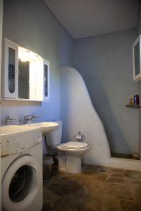 a bathroom with a toilet and a sink and a washing machine at Agkeria great feeling house in Kampos Paros +14 photos