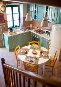 a kitchen with a table and chairs and a kitchen with green cabinets at Dvor strica Grge in Kaštelir
