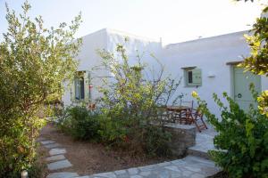a white house with a table and chairs in a garden at Agkeria great feeling house in Kampos Paros