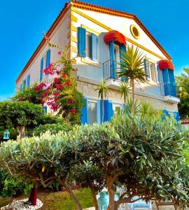 a building with blue windows and plants in front of it at Alacati Kayezta Hotel in Alacati