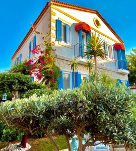 un edificio con ventanas azules y plantas delante de él en Alacati Kayezta Hotel, en Alacati