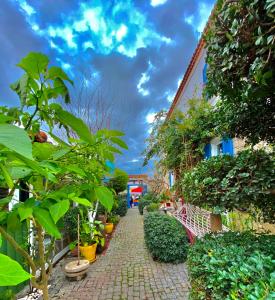 a cobblestone walkway with plants and a building at Alacati Kayezta Hotel in Alaçatı