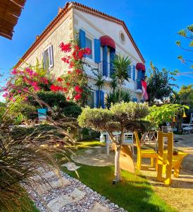 a house with blue shutters and a yellow bench in front of it at Alacati Kayezta Hotel in Alacati