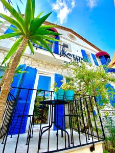a blue building with a palm tree in front of it at Alacati Kayezta Hotel in Alaçatı