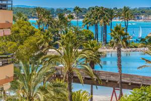 uma vista para um resort com palmeiras e uma ponte em Can Jaume em Port d'Alcudia