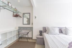 a bedroom with a bed and a chair and a mirror at Modern 3 Bedroom Duplex Adeje City Center Wifi in Adeje
