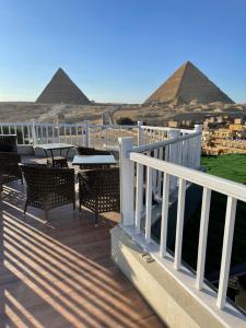um deque com cadeiras e as pirâmides ao fundo em Marvel Stone Hotel no Cairo