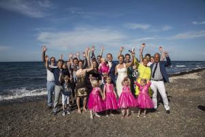 a group of people posing for a picture on the beach at En Plo Boutique Suites in Oia