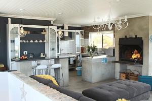 a kitchen with a fireplace and a living room at Kleinmond - Fairview on First in Kleinmond