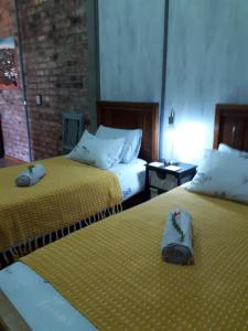 Dos camas en una habitación de hotel con zapatos. en RoamRooiberg, en Robertson