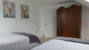 a bedroom with two beds and a wooden cabinet at Finn Loft in Ballybofey
