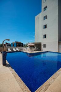 a large blue swimming pool next to a building at Hotel Baviera Iguassu in Foz do Iguaçu