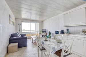 a kitchen and living room with a table and chairs at Le Gréement - Appt vue sur le port in Courseulles-sur-Mer