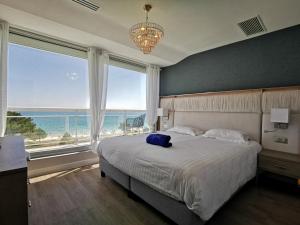 卡纳克Le Diana Hôtel & Spa的一间带大床的卧室，可欣赏海景