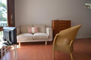 ein Wohnzimmer mit einem Sofa und einem Stuhl in der Unterkunft Appartement Pour 2 Personnes Vue Sur Le Port- Residence Jean Rameau in Hossegor