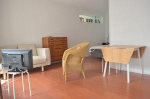 un soggiorno con TV, tavolo e sedie di Appartement Pour 2 Personnes Vue Sur Le Port- Residence Jean Rameau a Hossegor