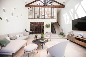 a living room with white furniture and a flat screen tv at Le Relais de la Godasse in Reyrieux