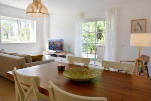 a living room with a wooden table and chairs at Doce Mar in Cabanas de Tavira