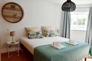 a bedroom with a bed and a mirror and a window at Doce Mar in Cabanas de Tavira