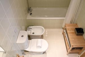 a bathroom with a toilet and a sink and a tub at Doce Mar in Cabanas de Tavira +31 photos