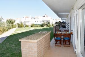 a patio with two chairs and a table on a house at Doce Mar in Cabanas de Tavira