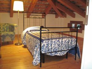 Bett in einem Zimmer mit einer Lampe und einem Stuhl in der Unterkunft Villa Pastori in Mira