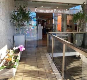 um centro comercial com vasos de plantas na frente de um edifício em Champagnat Praia Hotel em Vila Velha