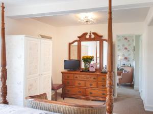 a bedroom with a dresser and a mirror at Court Prior Boutique B&B and Apartment in Torquay