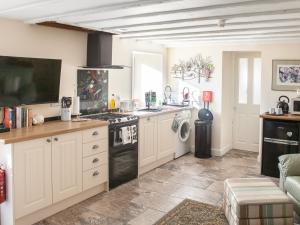 a kitchen with white cabinets and a stove top oven at Court Prior Boutique B&B and Apartment in Torquay