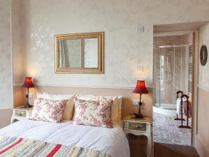 een slaapkamer met een bed met 2 lampen en een spiegel bij Court Prior Boutique B&B and Apartment in Torquay