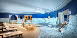 a bathroom with blue walls and a tub at Valamar Diamant Hotel in Poreč