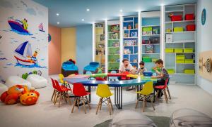two children playing in a play room with a table and chairs at Valamar Diamant Hotel in Poreč