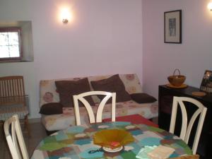 - un salon avec une table et un canapé dans l'établissement Maison du Chapitel, à La Sauvetat