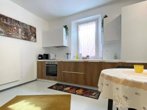 a kitchen with white cabinets and a table and a window at Ca' Sistina Yellow in Morcote