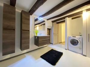 a laundry room with a washing machine and a sink at Ca' Sistina Yellow in Morcote