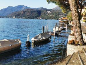 a group of boats tied to a dock on a lake at Ca' Sistina Yellow in Morcote
