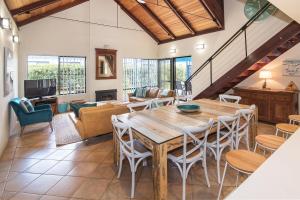 un soggiorno con tavolo e sedie in legno di Dunsborough Beach Cottages a Dunsborough
