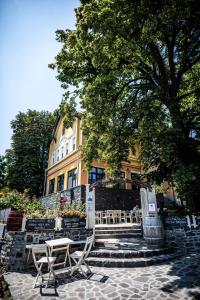 a couple of chairs sitting in front of a building at Neptun Badacsony in Badacsonytomaj