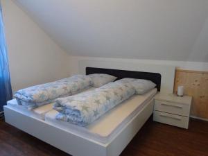 Cama en habitación con colchón y mesita de noche en Ferienwohnung Vogelsang, en Herdwangen-Schönach