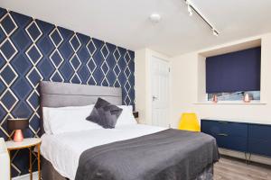 a bedroom with a bed and a blue wall at Whitby Bridge Luxury Apartments in Whitby