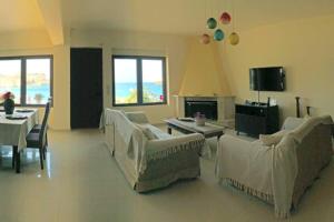 uma sala de estar com sofás e uma mesa e o oceano em Dreamwave Residence - Unique holidays by the sea em Ligaria